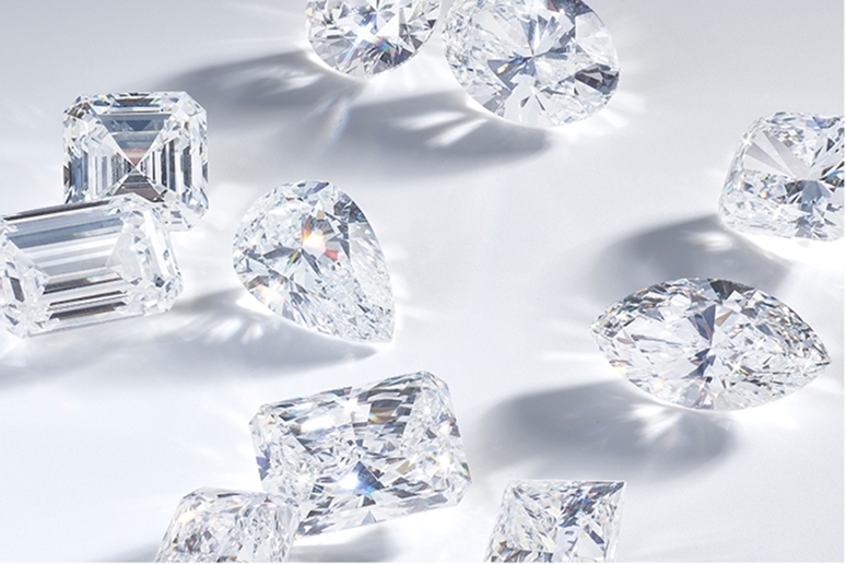 An image of loose diamonds scattered randomly on a white surface. Read more about the 4 C's.